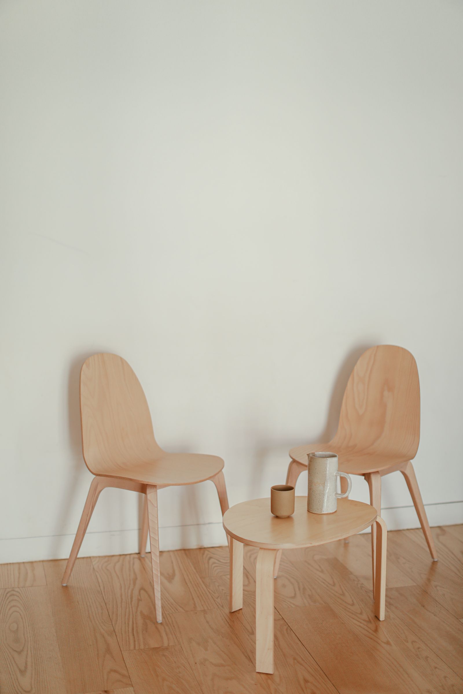 Two chairs angled toward each other beside a low table, prepared before a patient arrives